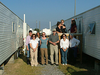 Displaced project researchers visiting a displaced University of New Orleans scholar's FEMA trailer, New Orleans, Louisiana, 2005. Lynn Weber is furthest to the left.
