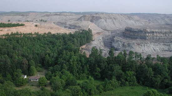 Vivian Stockman, A home on Mud River is dwarfed by the massive mountaintop removal mine that surrounds it, Lincoln/Boone County line, West Virginia, 2005.