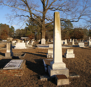 Ellen Schattschneider, Bishop Andrew memorial obelisk in the Andrew family plot (foreground) and the Kitty Tablet at the base of the Gateway Oak (background), Oxford, Georgia, 2005. 