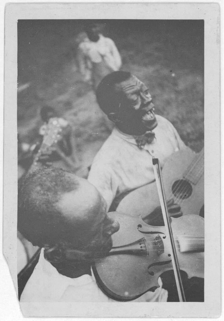 Wilson "Stavin' Chain" Jones playing guitar and singing the ballad "Batson" alongside fiddler Octave Amos, Lafayette, Louisiana, 1934. Photograph by Alan Lomax. The Lomax Collection, Library of Congress. Courtesy of The Library of Congress, Prints and Photographs Division, LC-DIG-ppmsc-00340. 