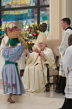 Archbishop Thomas Wenski receiving offertory gifts of fruits and native plants from parishioners, Notre Dame d'Haiti Catholic Church dedication service, Miami, Florida, February 1, 2015. Photo by Ana Rodriguez-Soto. Courtesy of the Archdiocese of Miami.