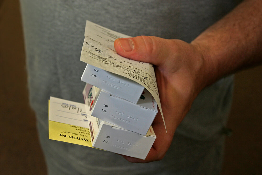 Miner holds medications and prescriptions for hypertension and stress. Clay Primary Health Care Clinic, Clay, WV, 2005.