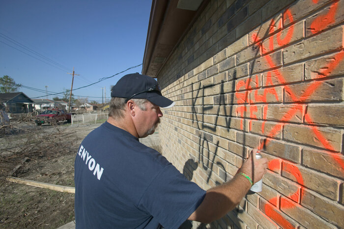 FEMA News Photo, New Orleans, Louisiana, October 2, 2005. Photograph by Andrea Booher. "Harlow Pickett from Kenyon marks a building with an 'all clear' search and rescue symbol. These were final searches for missing people in the Lower 9th Ward following Hurricane Katrina" (FEMA Caption).