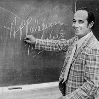 Black and white photograph of Jim Miller writing 'Appalachian literature' on a chalk board.