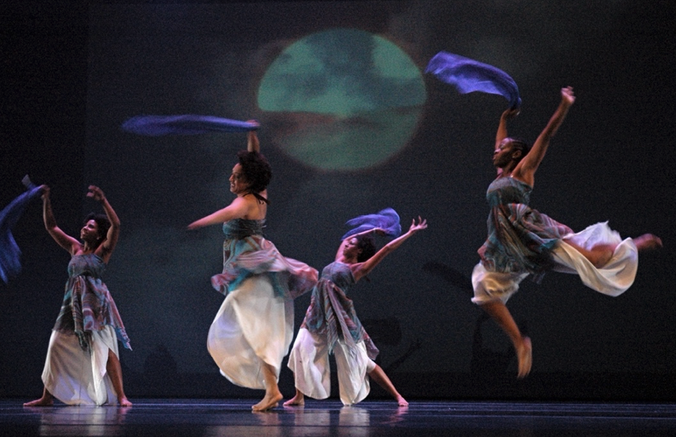 Four costumed and leaping dancers in Origin of Life on Earth, 2006 performance.