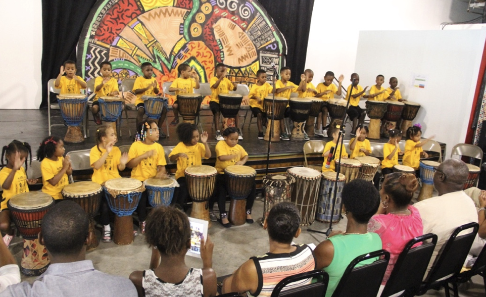 Two lines of children drumming at Kuumba Institute, Summer 2013.